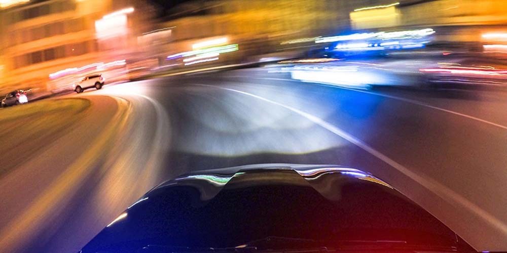 Blurry view from a car bonnet driving along a road