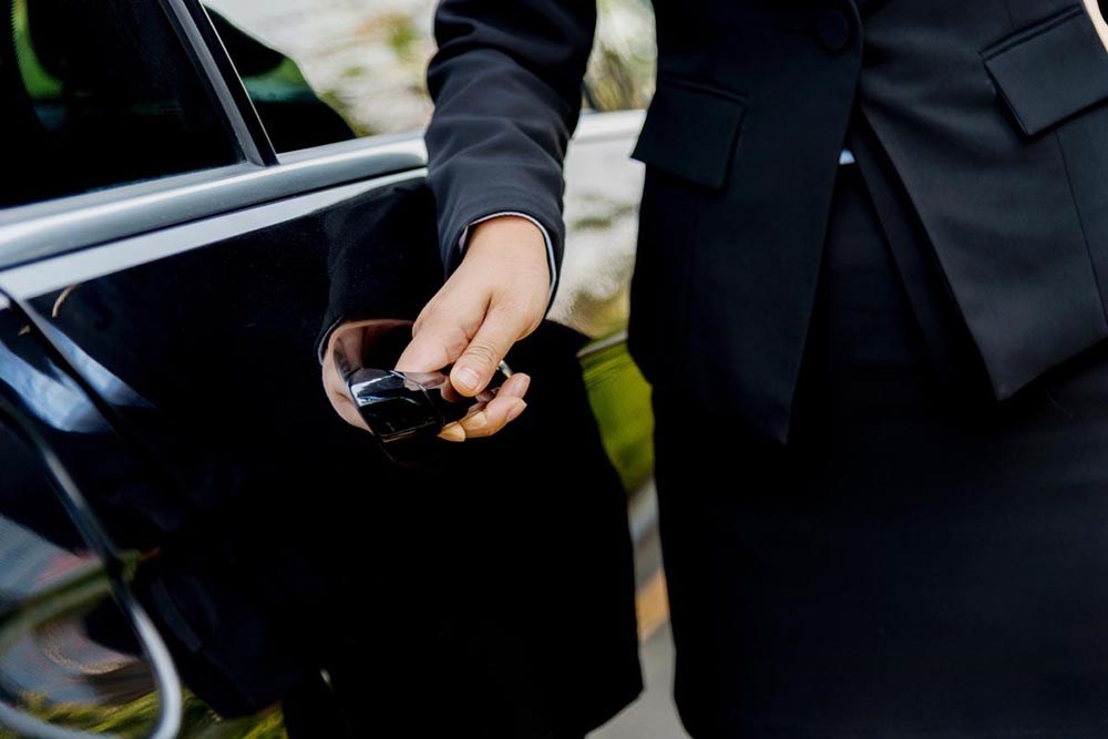 A chauffeur opening a car door